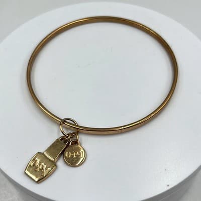 Vintage OPI Gold Tone Bangle Bracelet with Nail Polish Bottle & Logo Disc Charms - Image 1