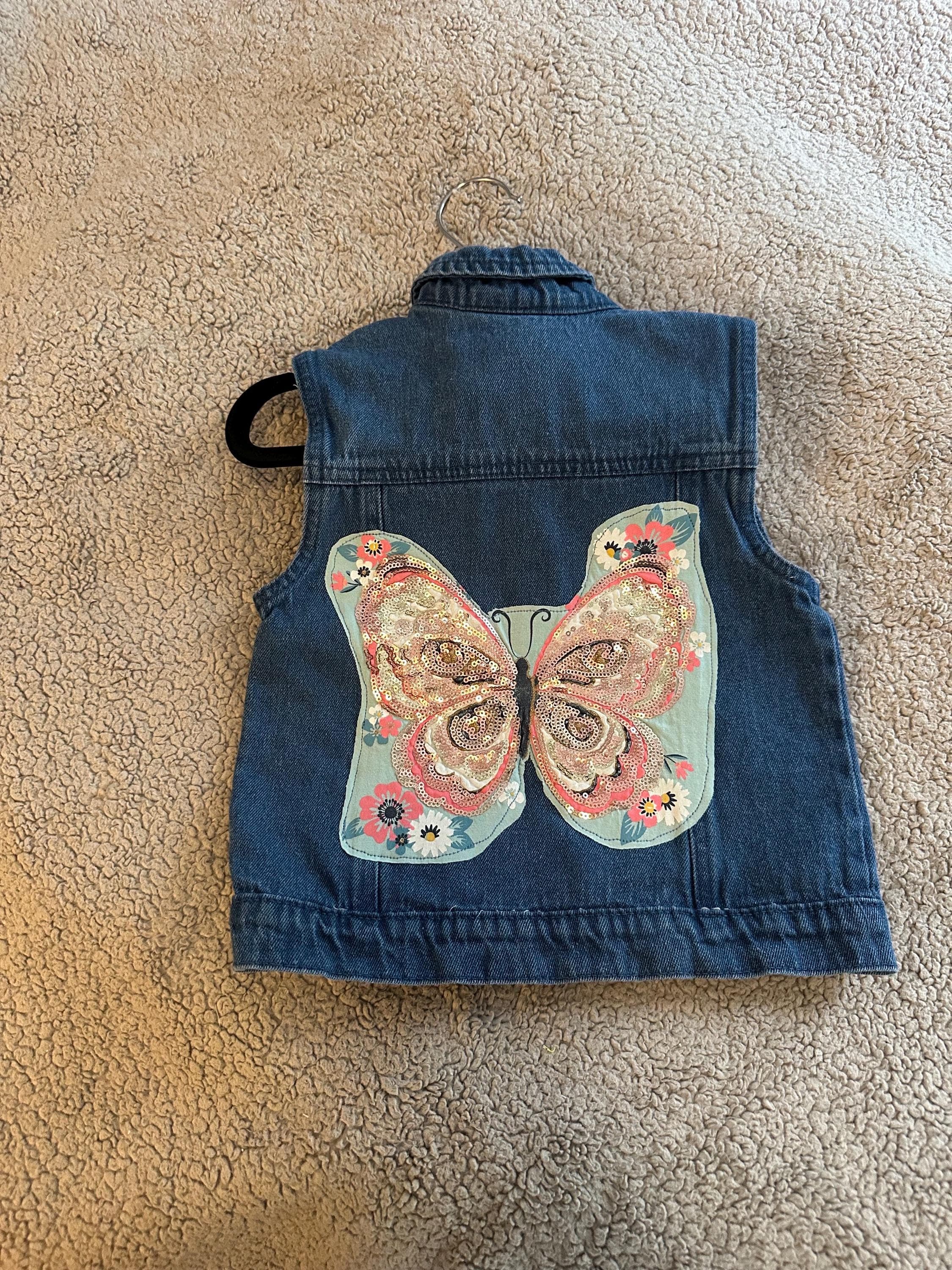 Denim vest with butterfly glitter on back with pink bows on front - Image 1