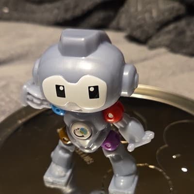 Gray Robot Toy Figure with Multicolor Arms - Image 1