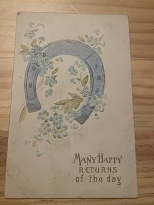 Vintage Embossed Postcard Many Happy Returns Horseshoe Blue Flowers Postmarked - Image 1