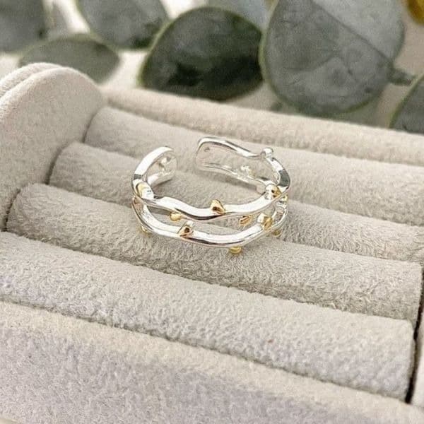 The Dainty Leaf adjustable silver ring with gold accents. - Image 1