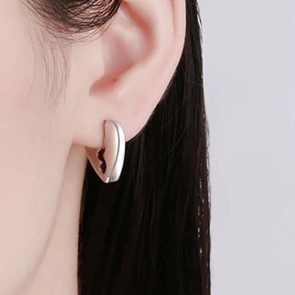 The Heart Chakra huggie earrings in silver - Image 1