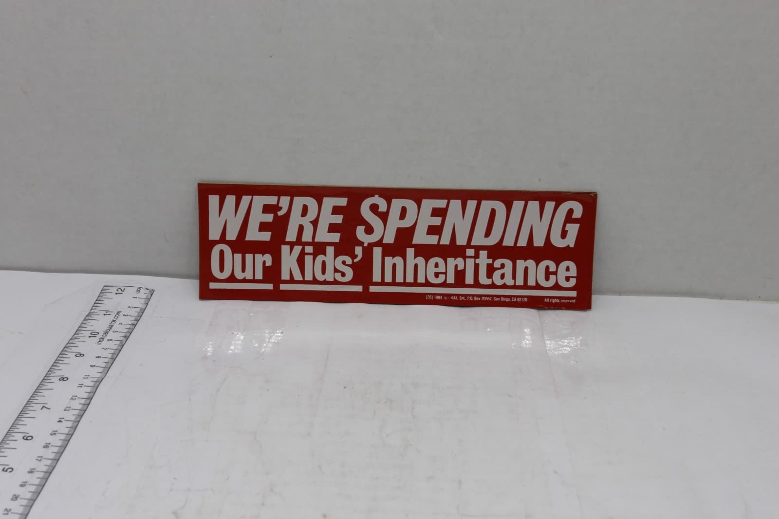10in x 3in Bumper Sticker "Were $pending over kids inheritance" Red & White - Image 1