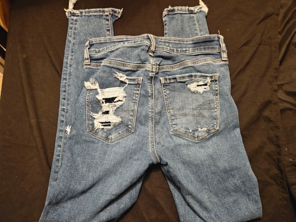 Distressed Blue Denim Jeans with Frayed Hems - Image 1