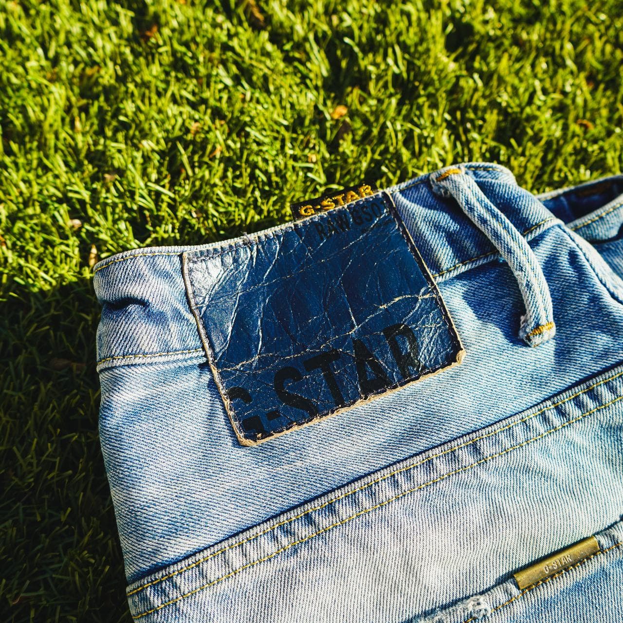 G-STAR Raw jeans in Men's Size 30. Features a light faded wash, with Japanese-style draped legs. Denim shows distress on the front, and back, and features G-STAR logo details throughout. - Thumbnail 2