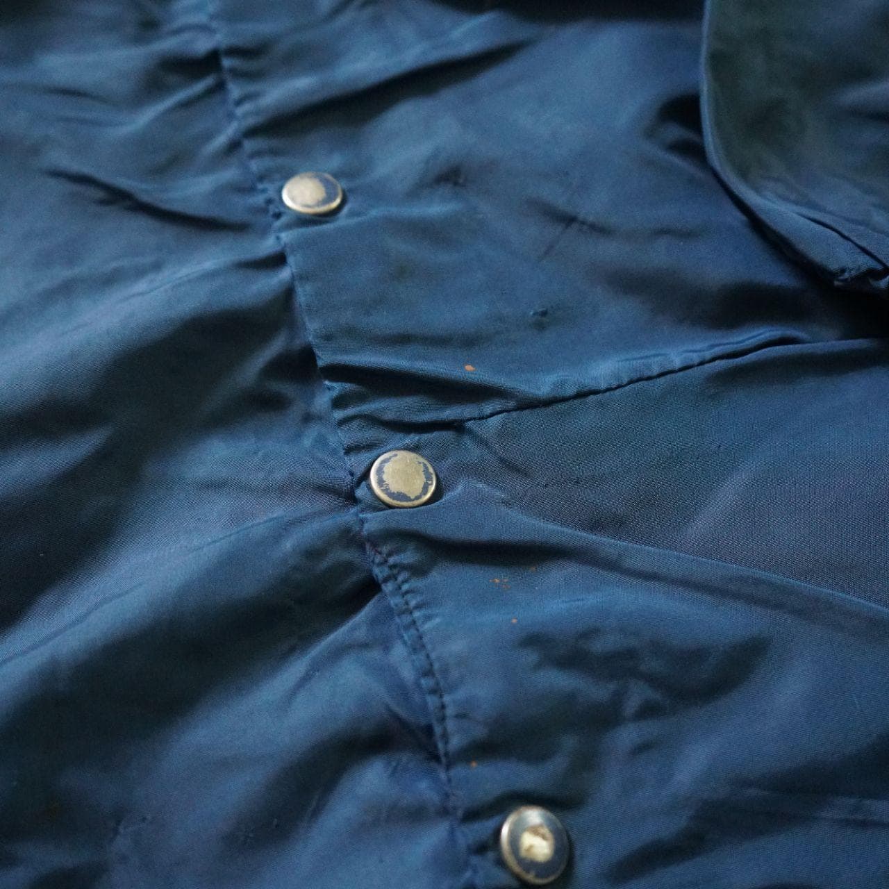 Vintage Coaches jacket in navy with button closure. The jacket is estimated to be from the 70/80s collected in Maryland. No size tag, but fits like an L or XL. Features authentic vintage aging throughout and elastic sleeve closures. - Thumbnail 4