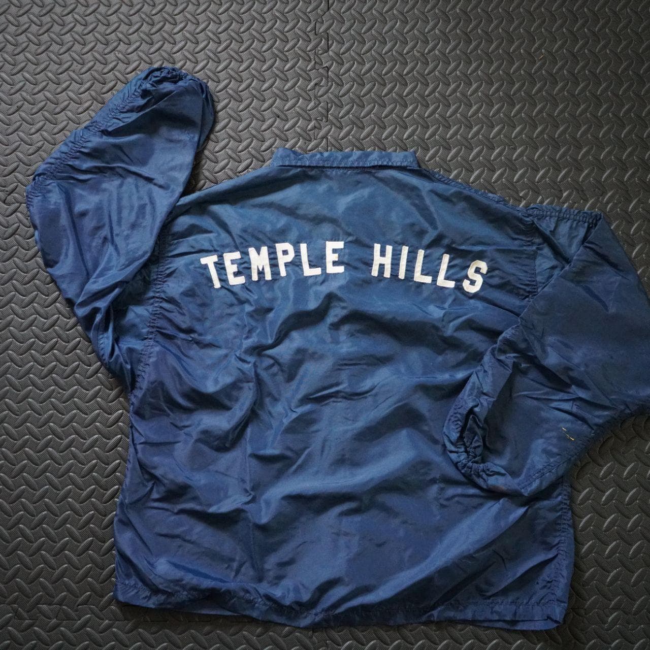 Vintage Coaches jacket in navy with button closure. The jacket is estimated to be from the 70/80s collected in Maryland. No size tag, but fits like an L or XL. Features authentic vintage aging throughout and elastic sleeve closures.