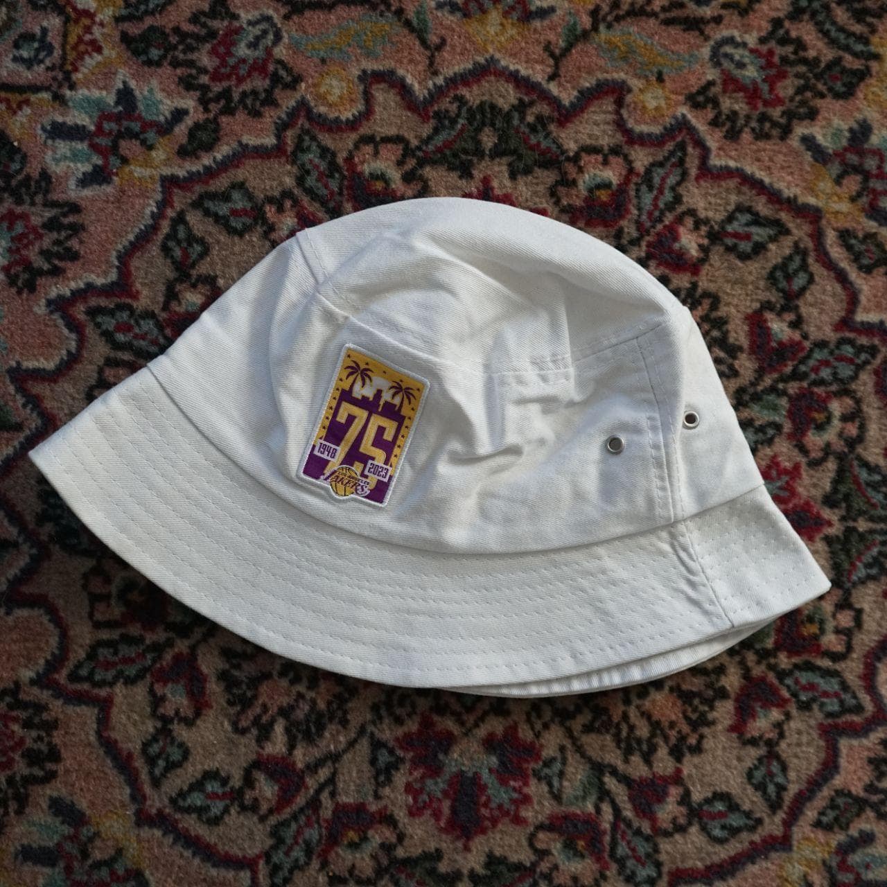 75th Anniversary edition NBA Lakers bucket hat. White hat with metal grommets and a commemorative Lakers patch. *Never worn*