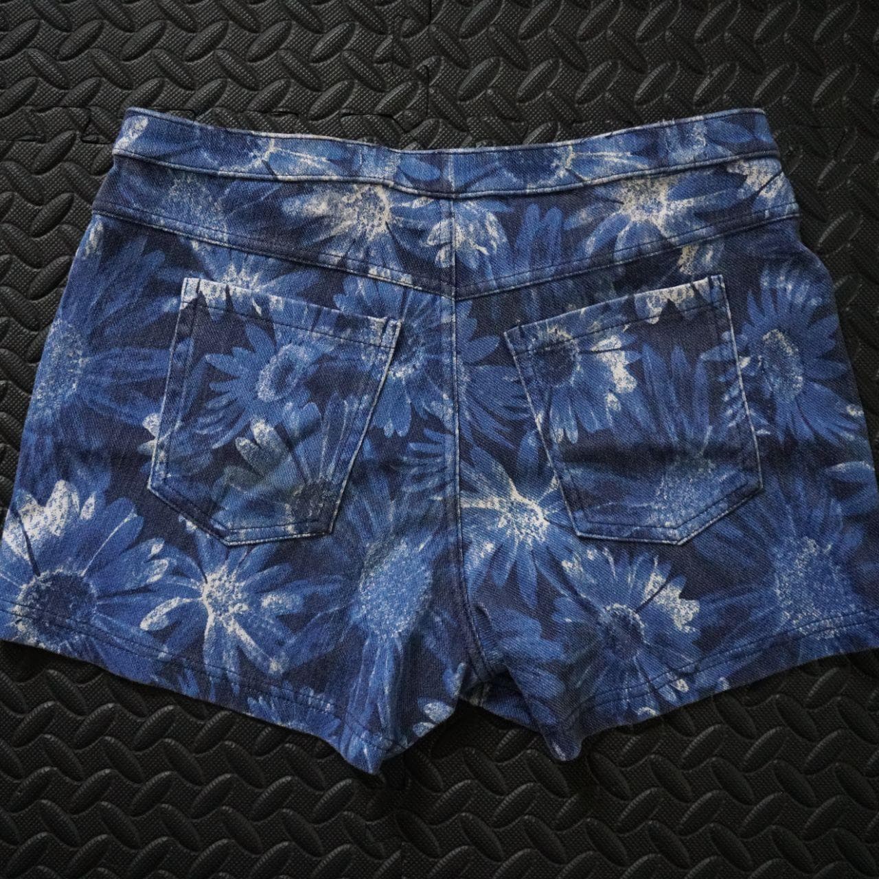 Vintage women's stretchy denim short shorts in a size medium. Super soft shorts with an elastic waistband and back pockets. Features flower pattern all over.