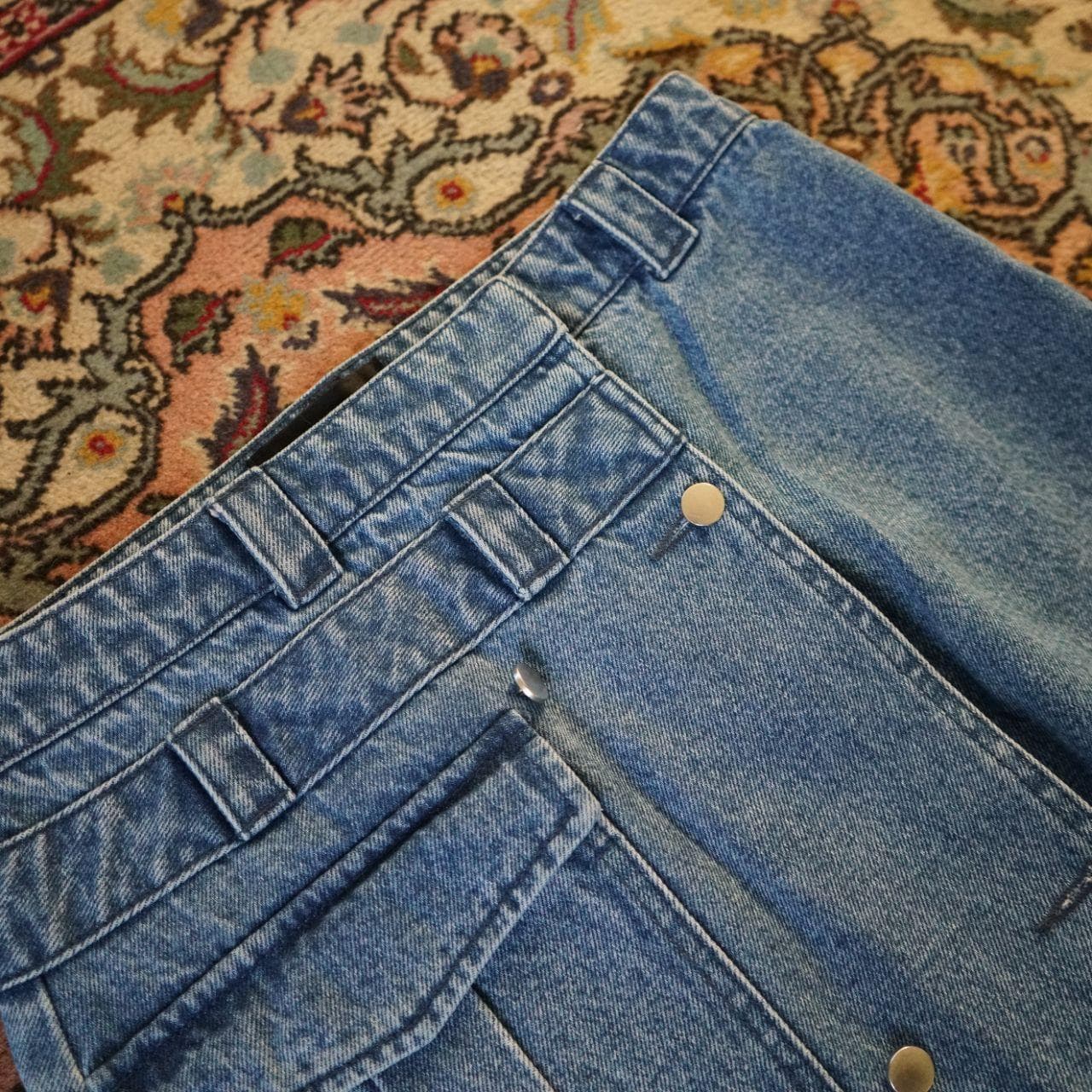 Very cute assymmetrical denim skirt in women's small. Features a front pocket, button closure, and asymmetric bottom. - Thumbnail 2