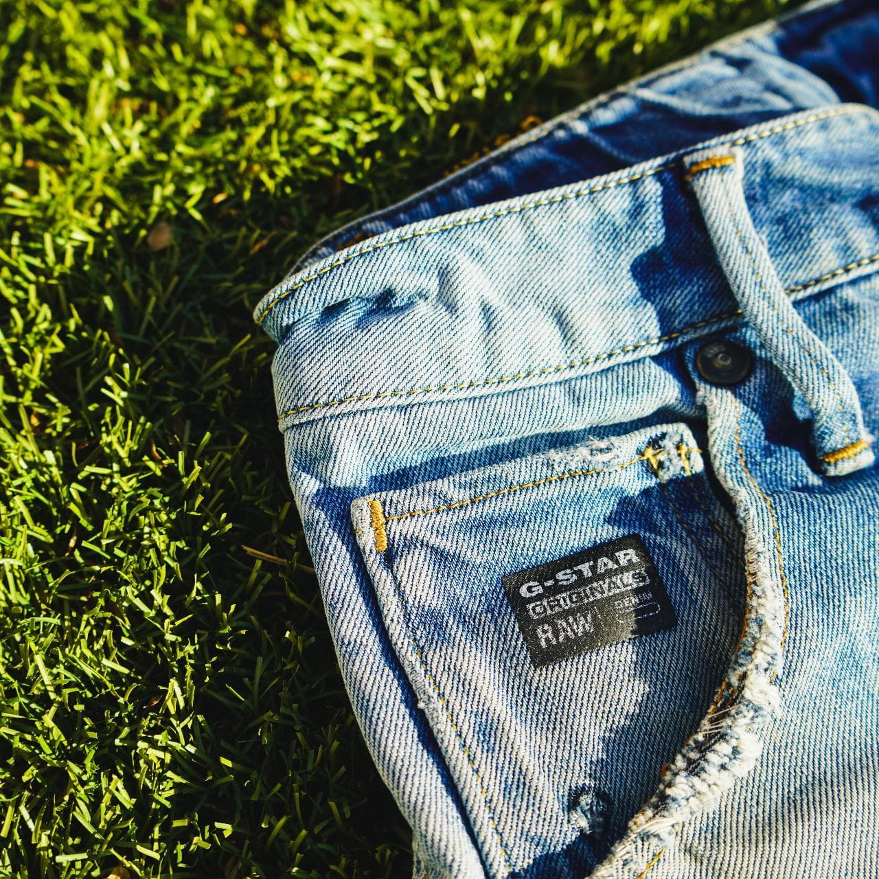 G-STAR Raw jeans in Men's Size 30. Features a light faded wash, with Japanese-style draped legs. Denim shows distress on the front, and back, and features G-STAR logo details throughout. - Thumbnail 4
