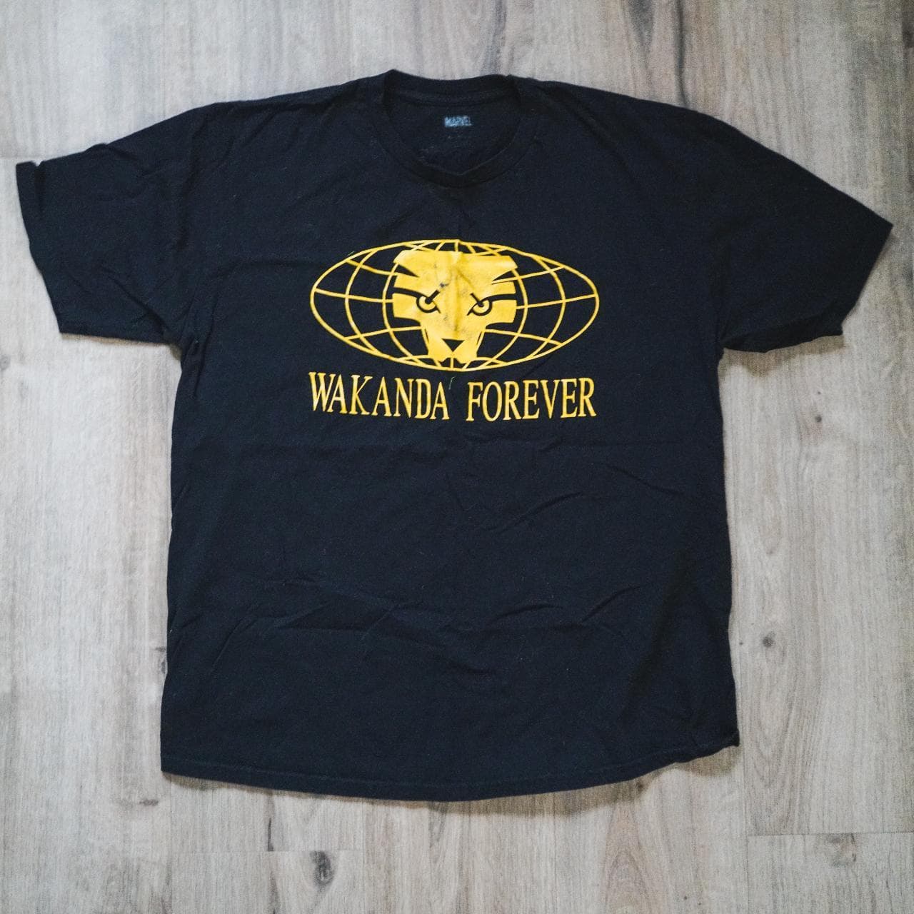 Marvel Comics, "Black Panther" #Wakanda Forever tee in black with yellow screenprint on front. Size XL. #cinema