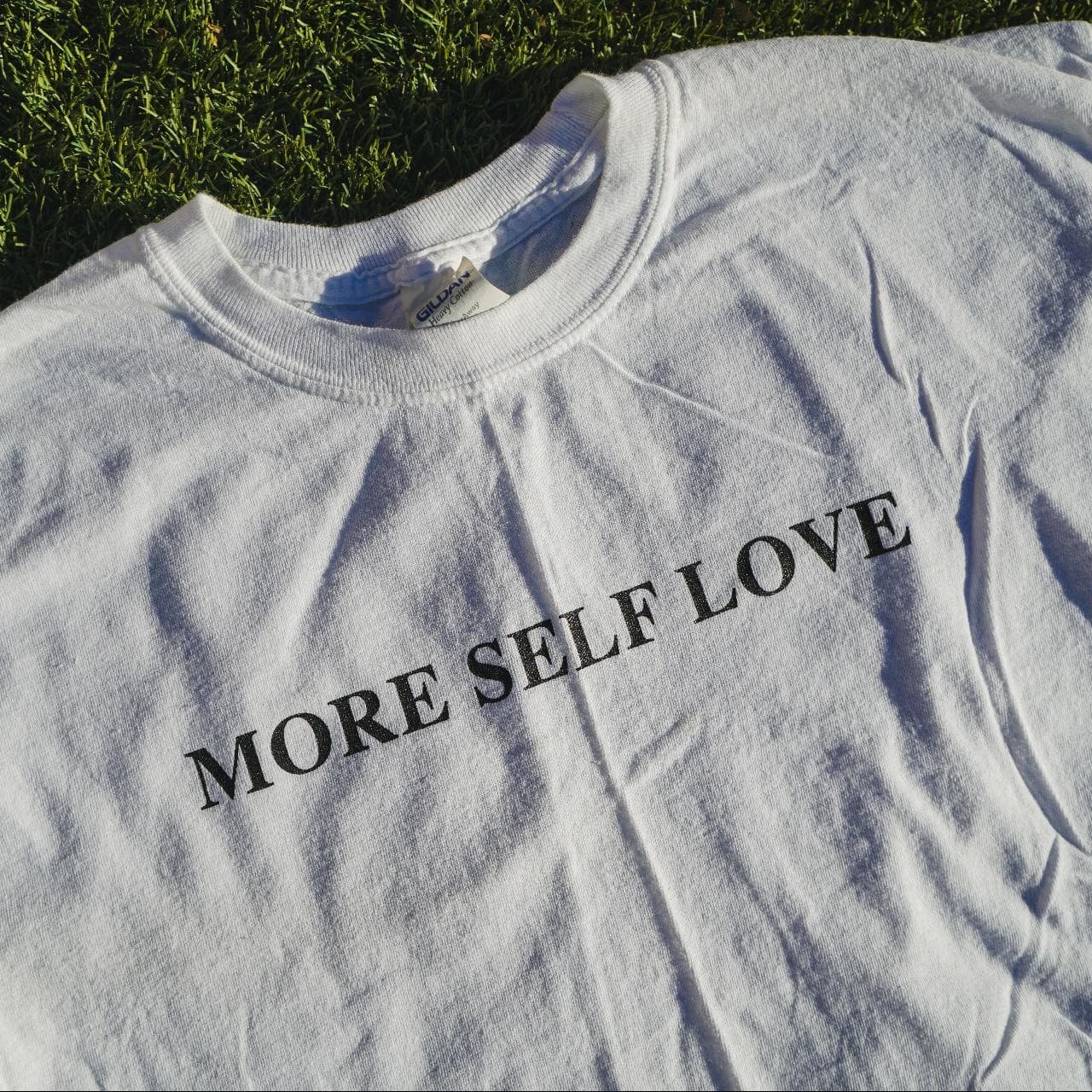 "More Self Love" long-sleeve cropped tee. Size women's medium. Features screen print text on the front and flowers on both sleeves. Seamless cropped bottom 🍉 - Thumbnail 2
