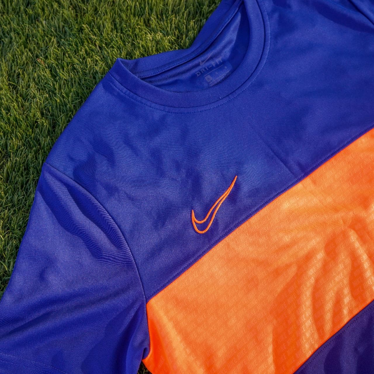 Nike soccer jersey in royal blue, navy, and highlighter orange. It features an embroidered logo, monogram print throughout, and dri-fit material. Size: adult large. - Thumbnail 2