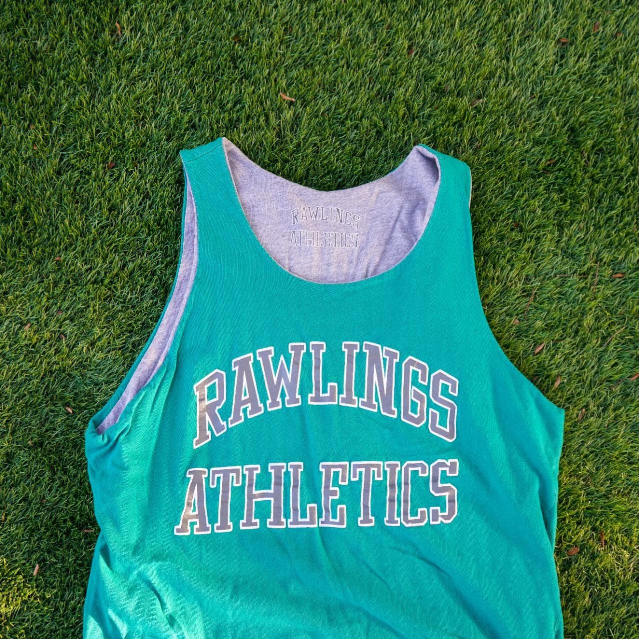 Vintage Russell Athletics reversible tank in teal and gray. Fits like an adult Large. Features graphics on both sides, with a logo tag, and a brand patch.