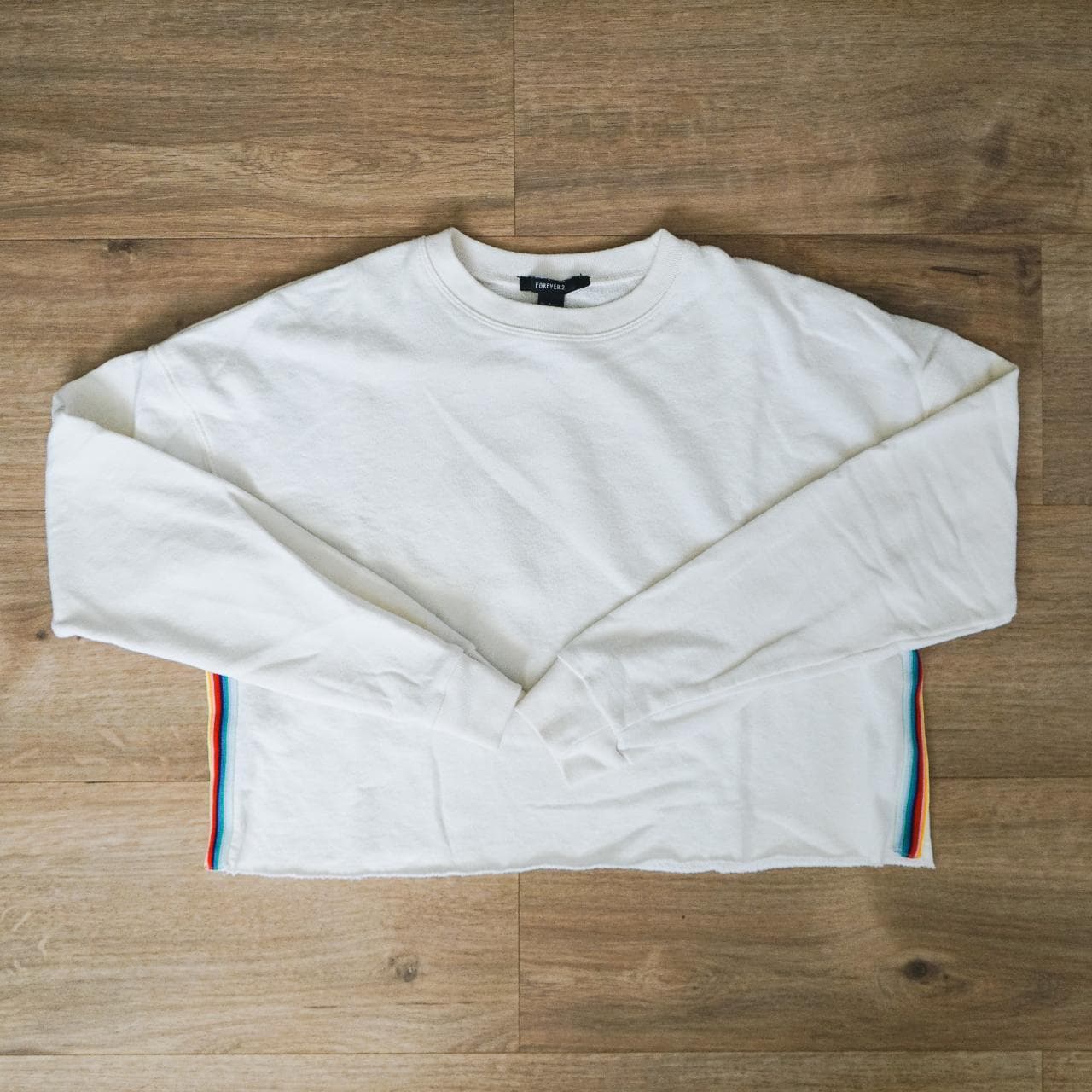 Cropped white pullover sweatshirt with rainbow accent stripe. A simple crop that can be dressed up or down. Women's size small 🌈