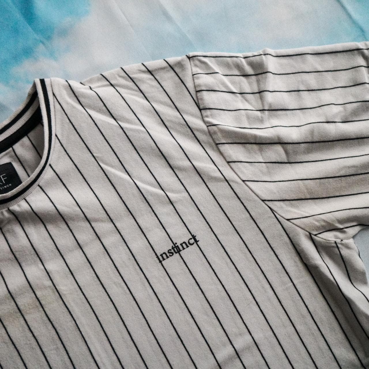White and black pin striped shirt with a small "Instinct" logo on the front. Features contrast sleeve cuffs. Size adult small 👟 - Thumbnail 2