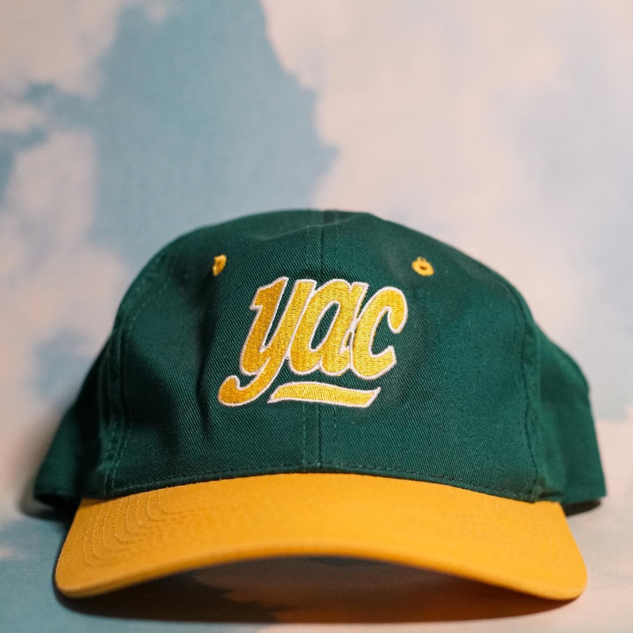Green and yellow vintage snapback with "yac" on front. Features yellow under brim and adjustable snapback closure 🧢
