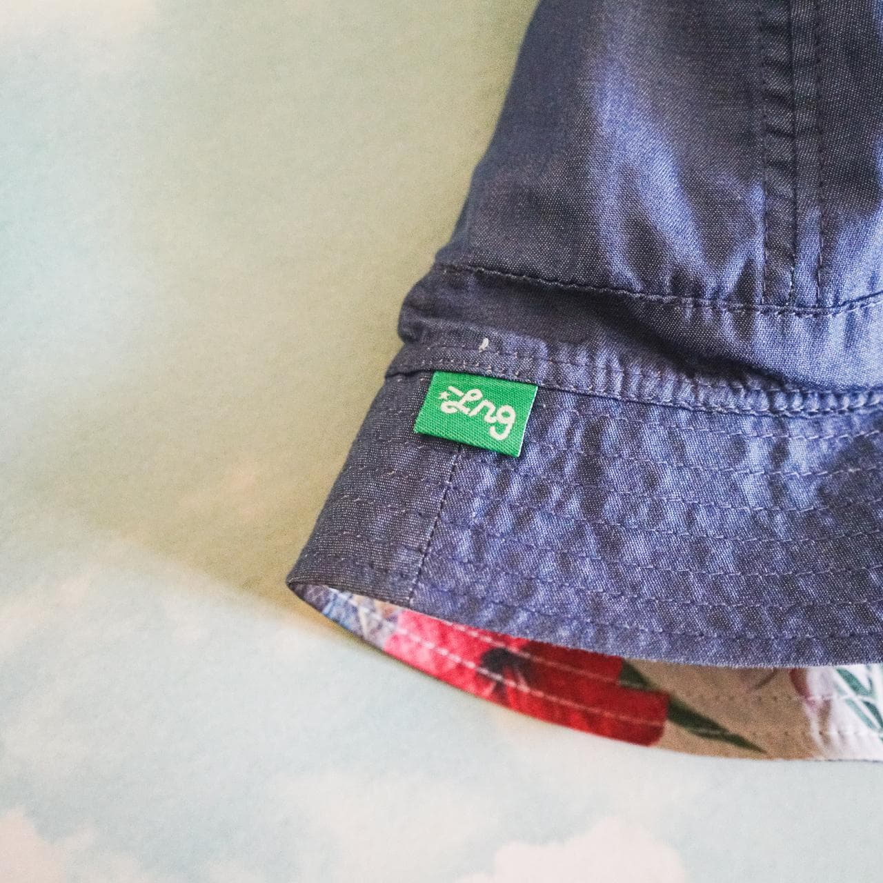 Crazy #LRG reversible bucket hat. Features medium-washed denim on one side with logo tag and full-color tropical print on the other side. The Y2K style is back and this accessory is perfect for the Summer 🌲 - Thumbnail 3