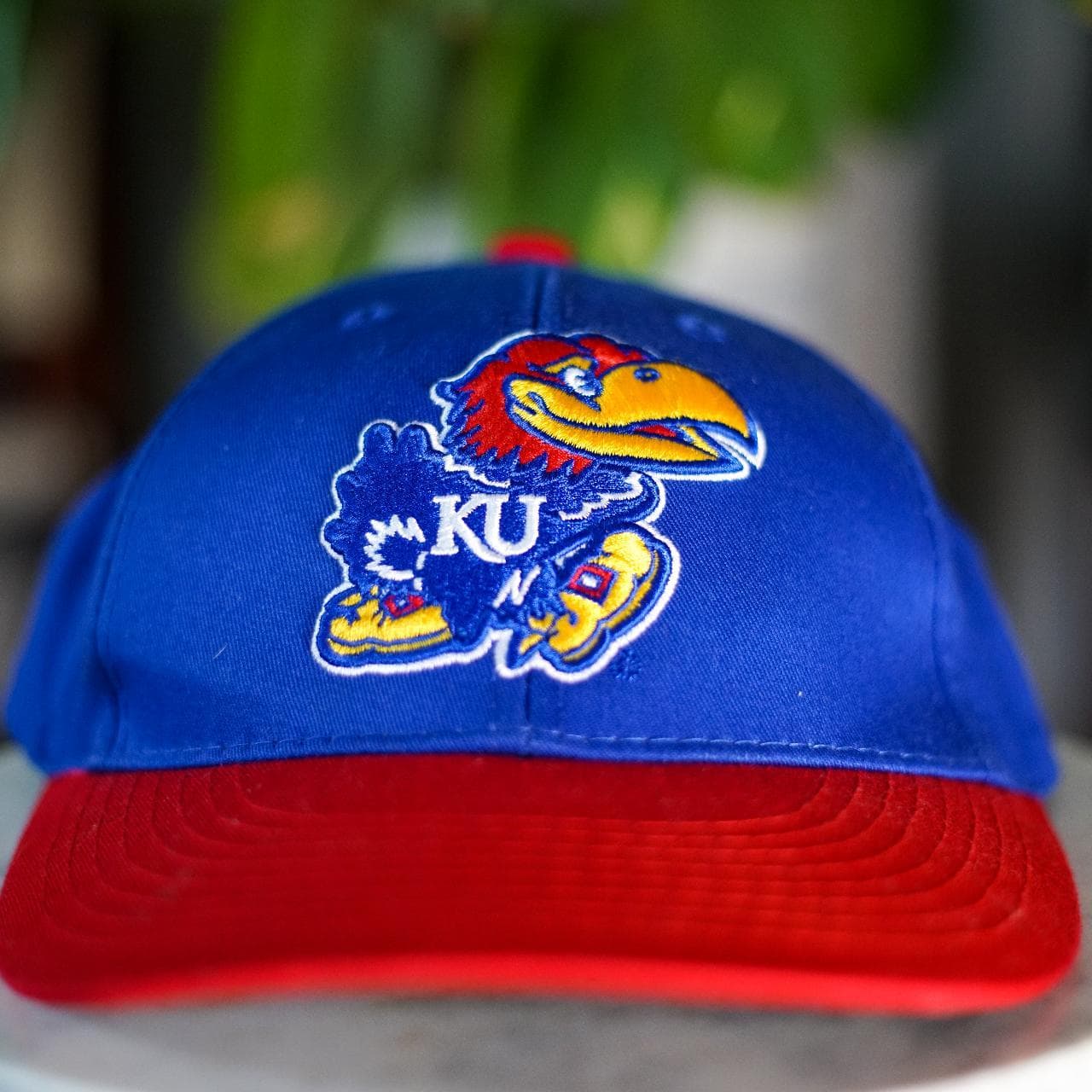 Kansas University baseball cap with velcro closure. Grey underbrim with school logo on front and "KANSAS" on the back 🧢