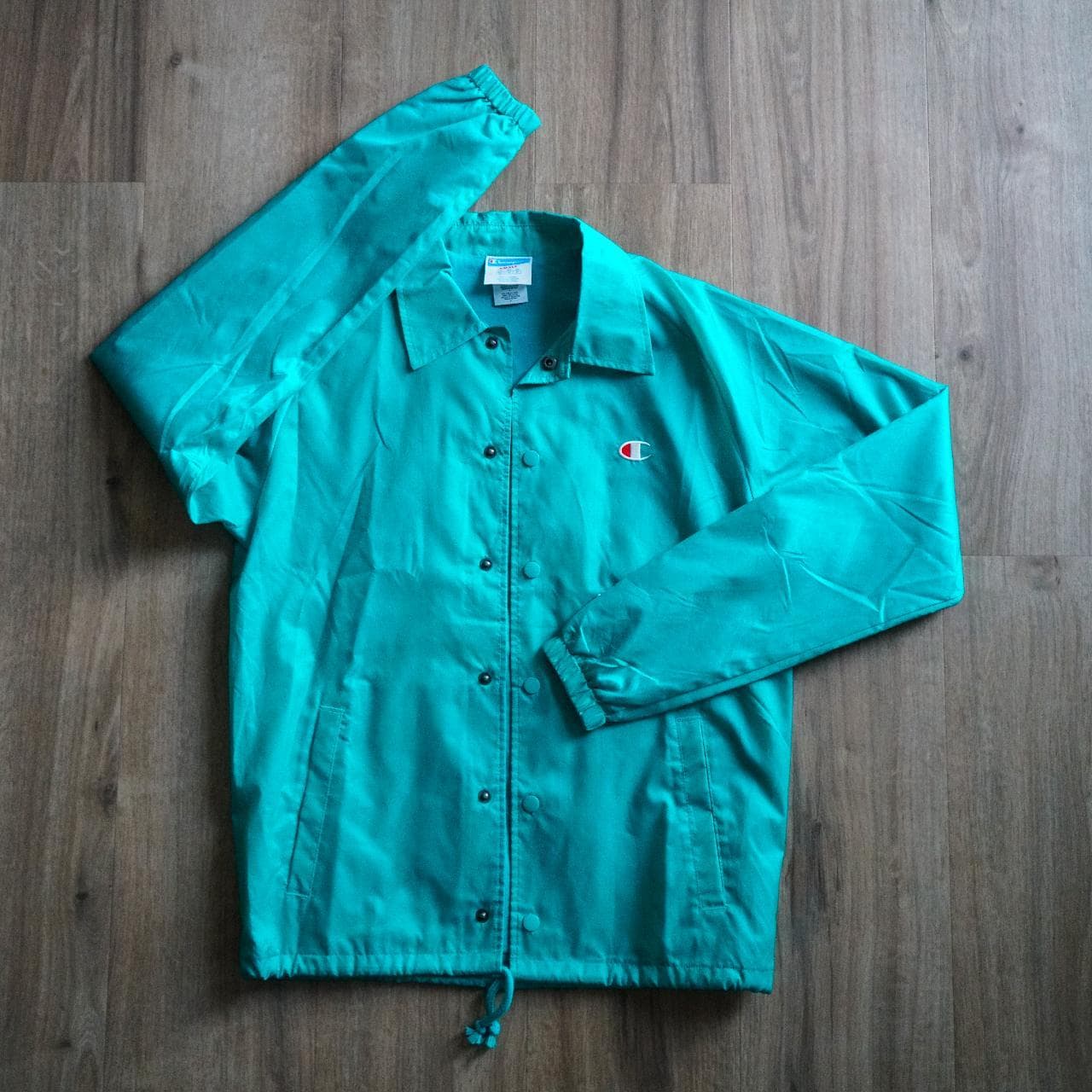 Turquoise #Champion coach's jacket with logo accent 🦋 Features snap button closure, drawstring, and elastic sleeves. Size adult small.