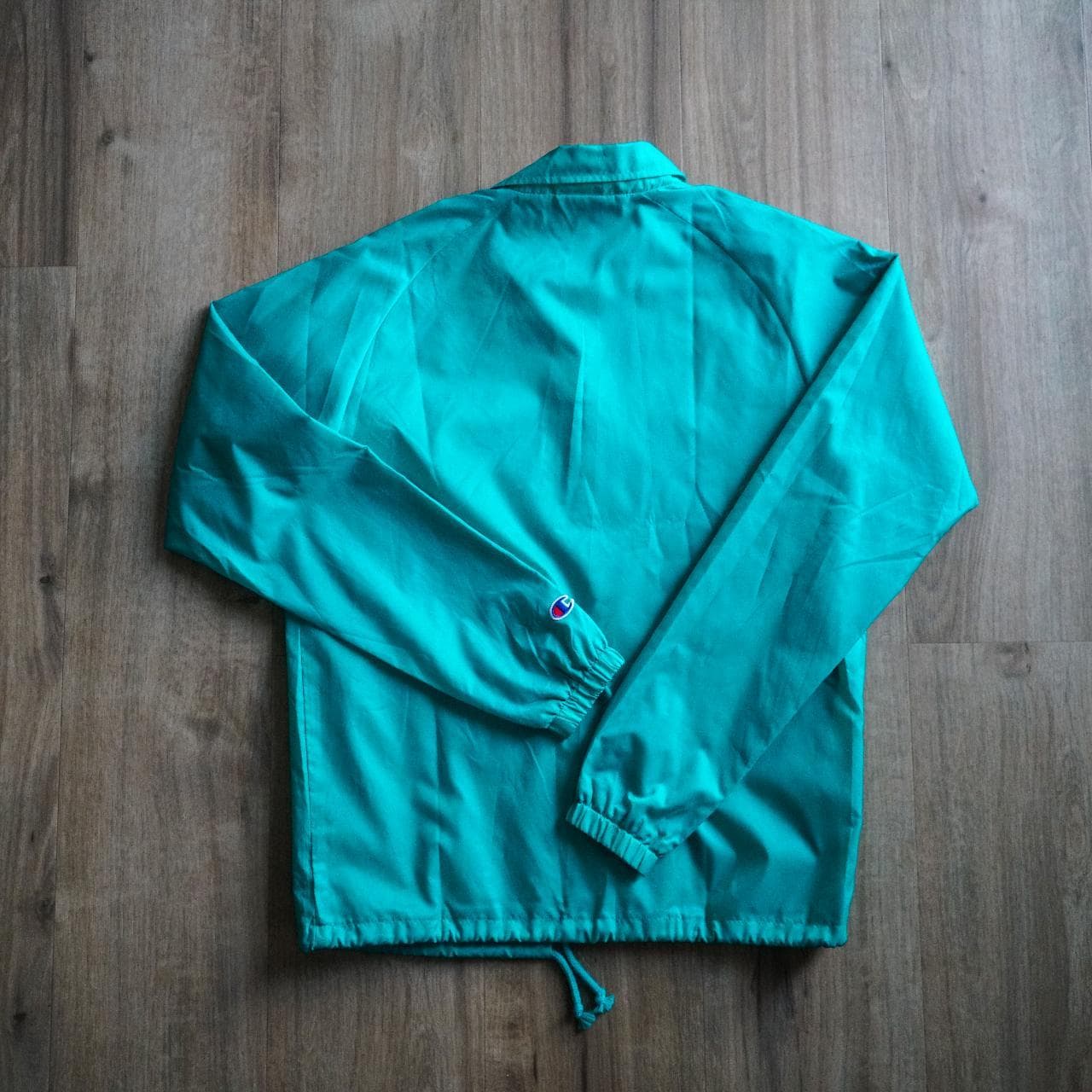 Turquoise #Champion coach's jacket with logo accent 🦋 Features snap button closure, drawstring, and elastic sleeves. Size adult small. - Thumbnail 4