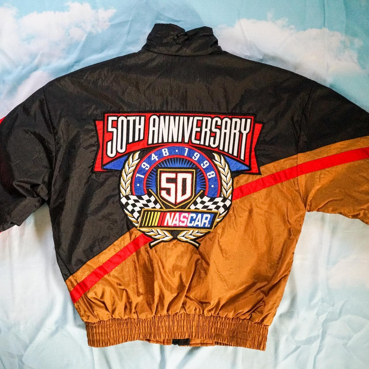 1998, 50th Anniversary #NASCAR insulated jacket. Features a black and gold base with red accents and embroidered graphics on the front chest and back. Snap and zip closures with front pockets 🏎 Size small, fits oversized.