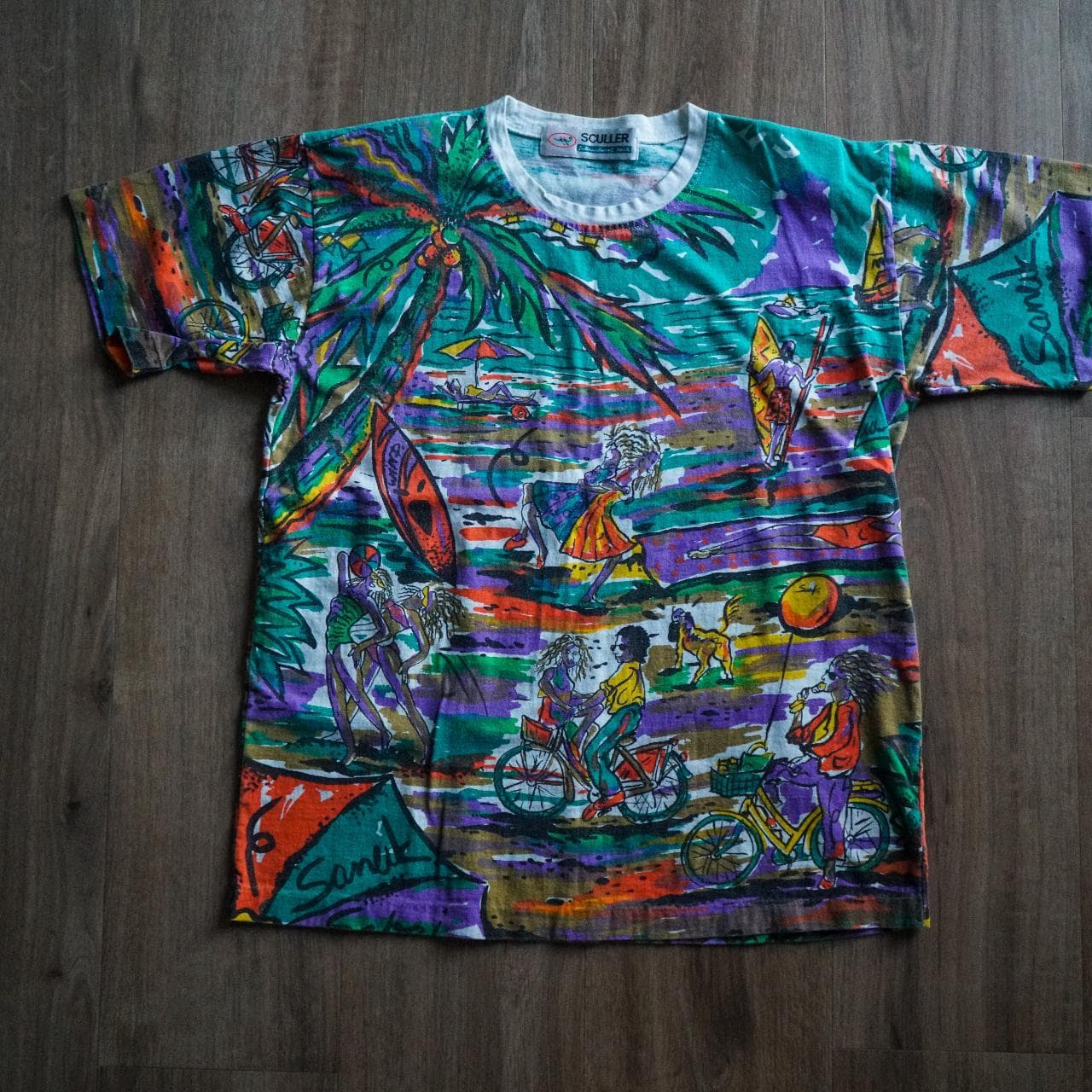 Vintage all-over print tee in vibrant multi-color. The shirt depicts a tropical beach scene. Size adult medium.