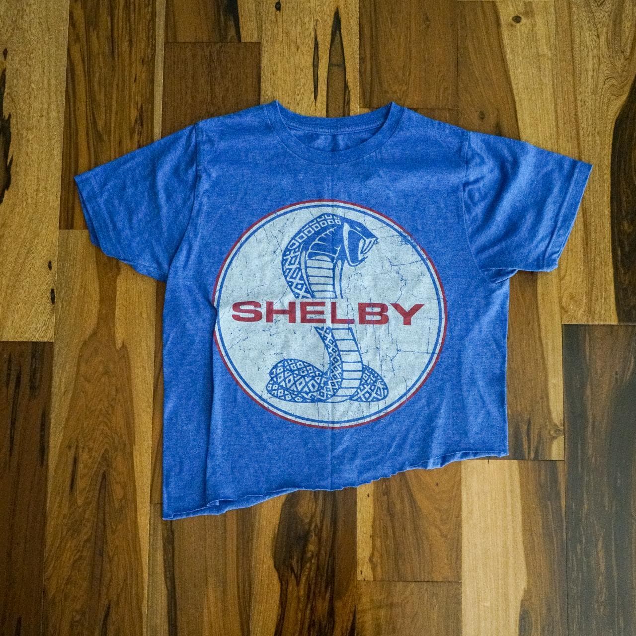 Shelby #Mustang tee in royal, white, and red. Graphic on the front with an asymmetrical bottom.