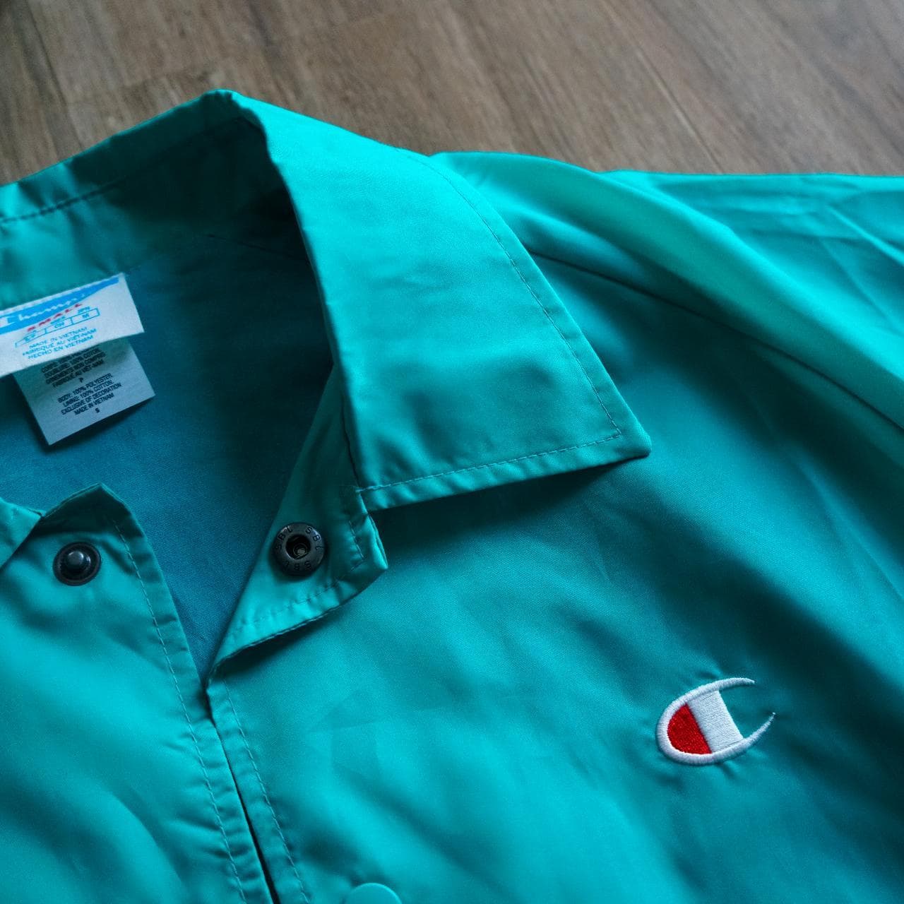 Turquoise #Champion coach's jacket with logo accent 🦋 Features snap button closure, drawstring, and elastic sleeves. Size adult small. - Thumbnail 2