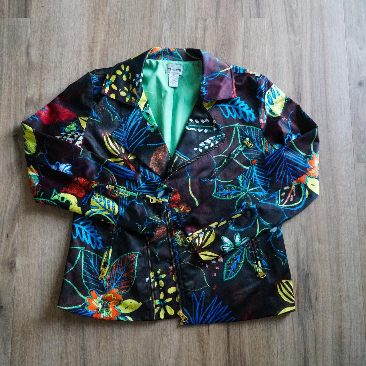 Women's printed riding jacket by #Chicos in size 0 🧥 Chico's is known for their alternative sizing. The jacket fits like a women's 4/6. Features gold accents, green lining, and pockets throughout.