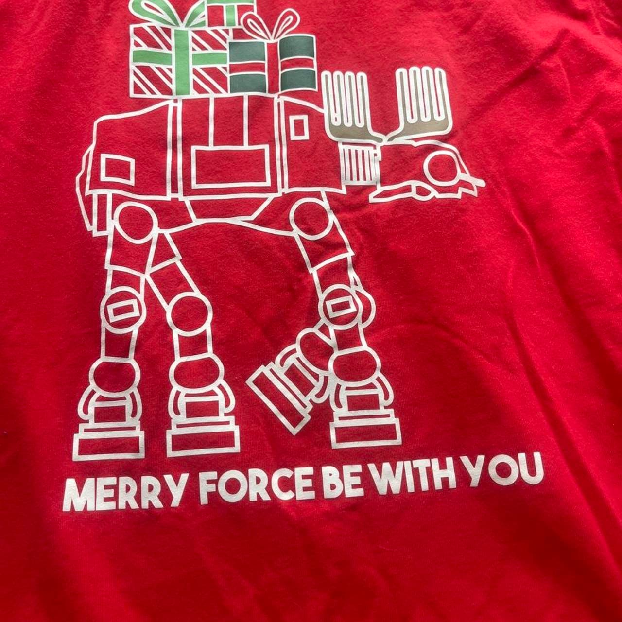 Celebrate the holidays with a galactic twist in this officially licensed Star Wars Christmas long sleeve T-shirt. Featuring an AT-AT Walker carrying a stack of Christmas presents and the festive phrase “Merry Force Be With You,” this bright red tee is perfect for Star Wars fans during the holiday season. - Thumbnail 2