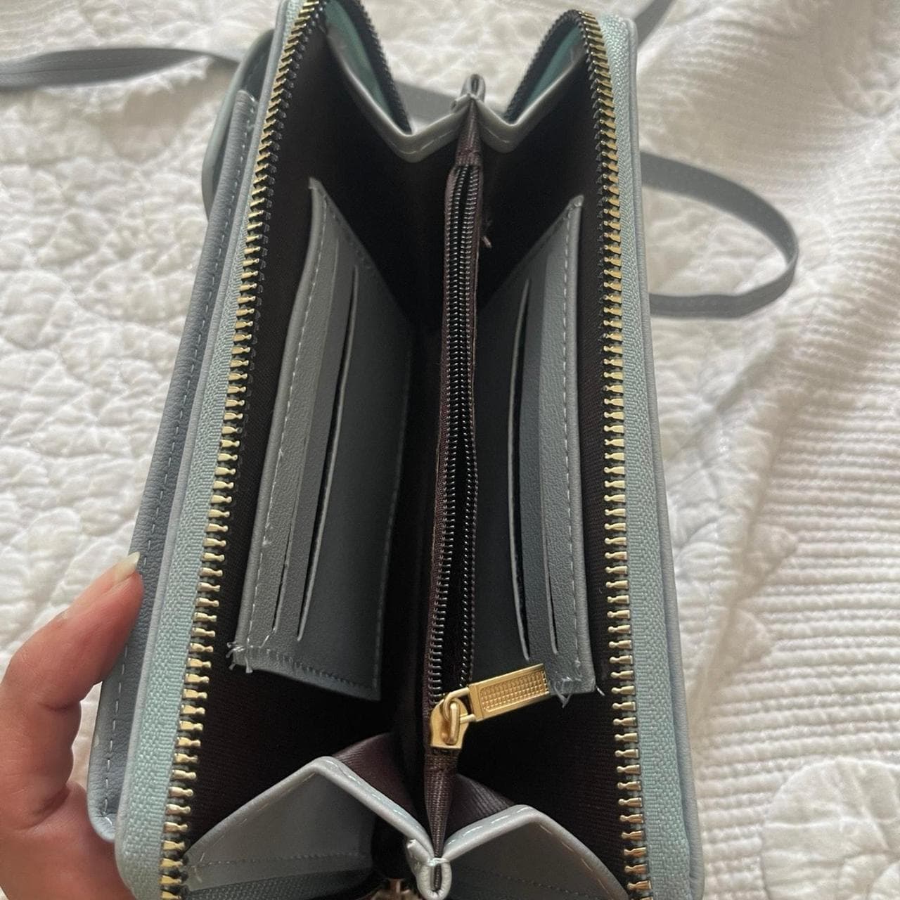 Keep your essentials organized in style with this Forever Young crossbody phone wallet. Designed in a soft light blue faux leather finish, this compact bag features a dedicated phone pocket, multiple card slots, cash compartments, and a secure zip-around wallet interior. The adjustable crossbody strap makes it perfect for errands, travel, concerts, or everyday use when you want to carry just the essentials. - Thumbnail 2