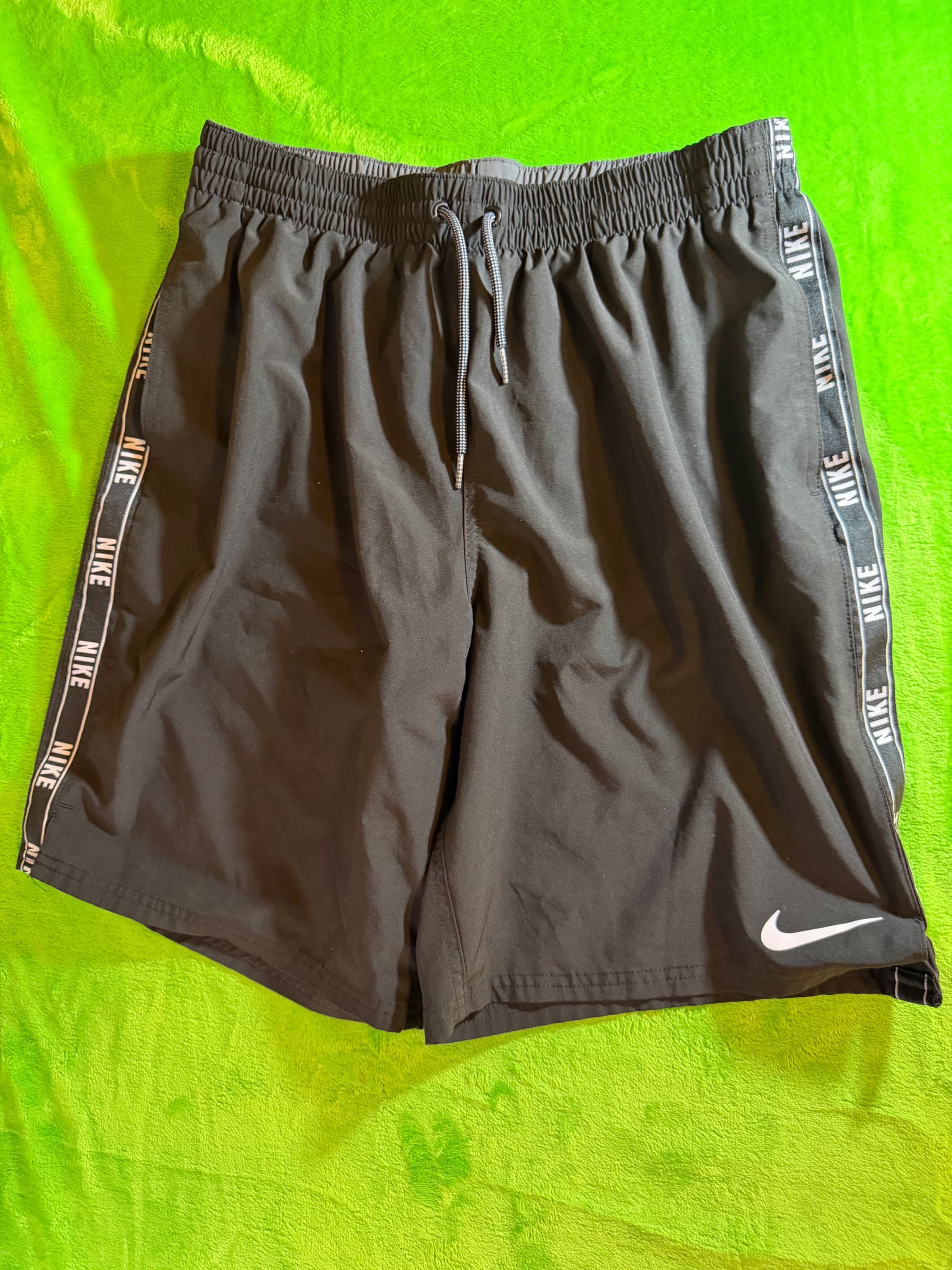 Nike black volleyball-style swim shorts featuring white logo-branded tape