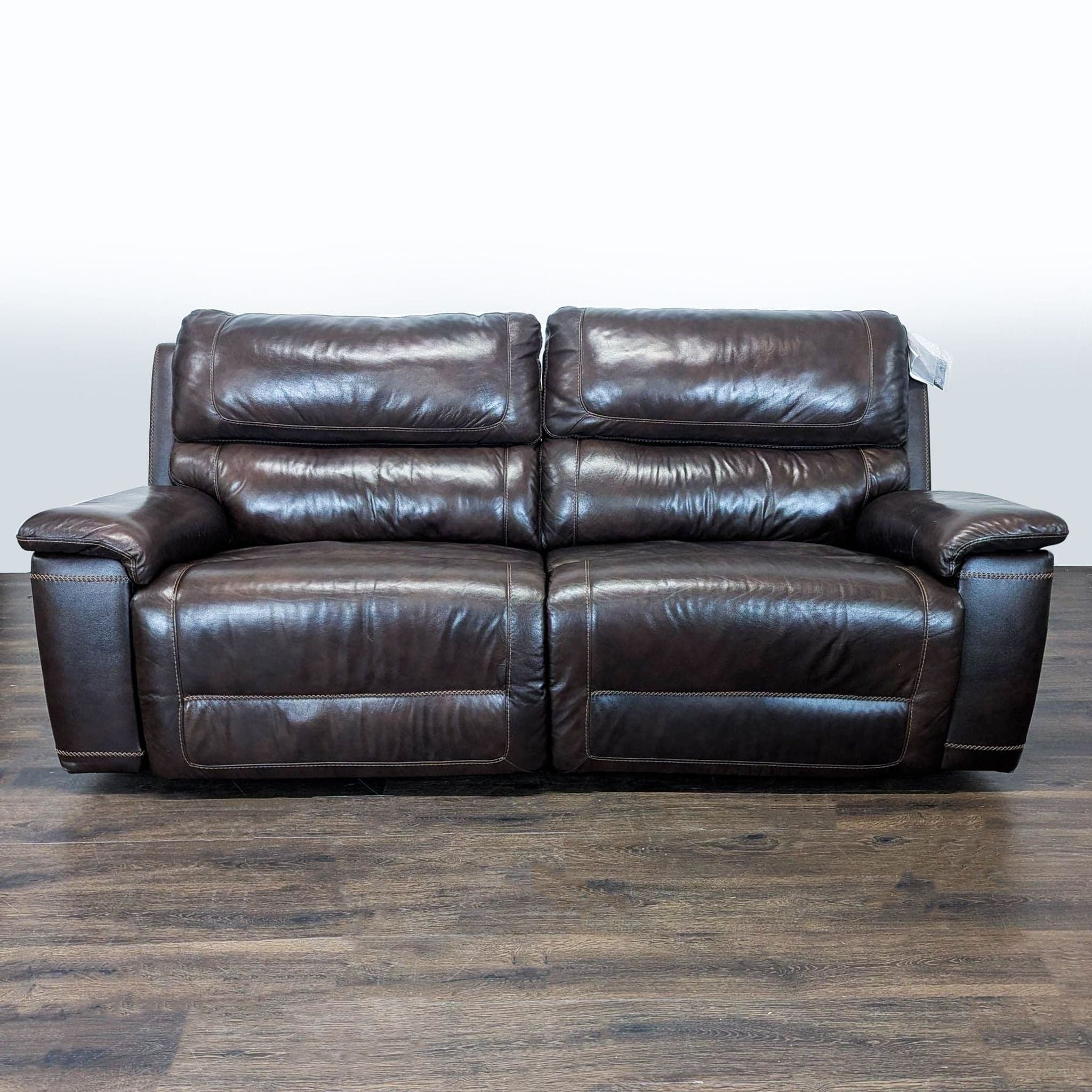 Brown Leather Reclining Loveseat with Plush Cushioning and Wide Armrests
