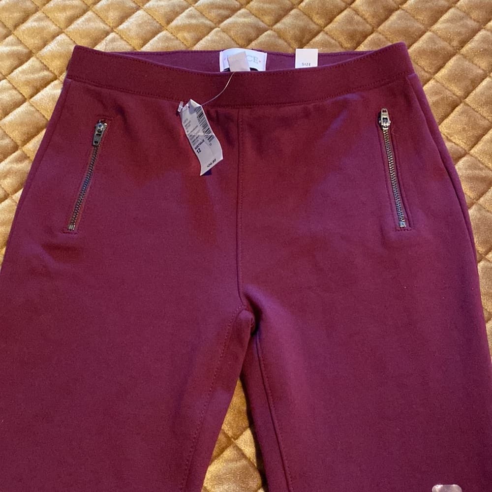 Place burgundy leggings with zipper accents (no pockets)