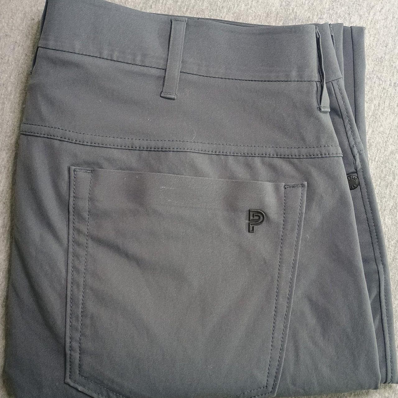Public Rec All Day Every Day 5-Pocket Performance Pant in a versatile slate blue/grey. These technical chinos offer the comfort of sweatpants with the look of dress slacks, featuring high-stretch performance fabric and a classic 5-pocket design.