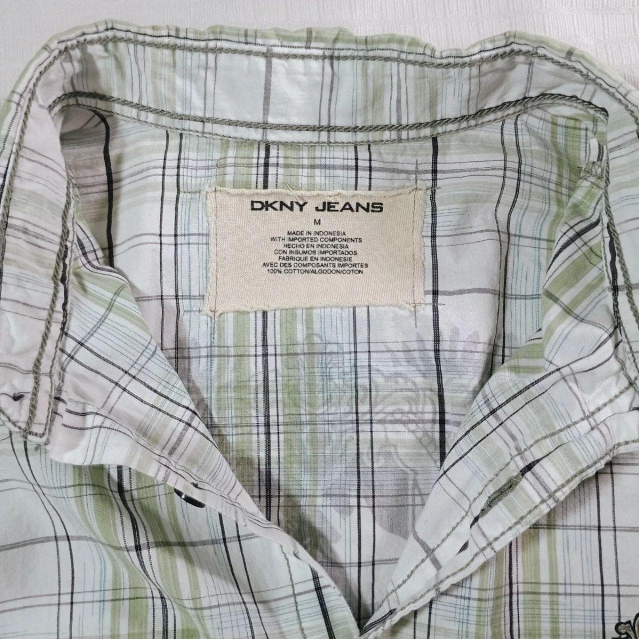 The DKNY Jeans Rock & Roll Button Down Plaid Shirt in Size Medium is a stylish and comfortable addition to any casual wardrobe.