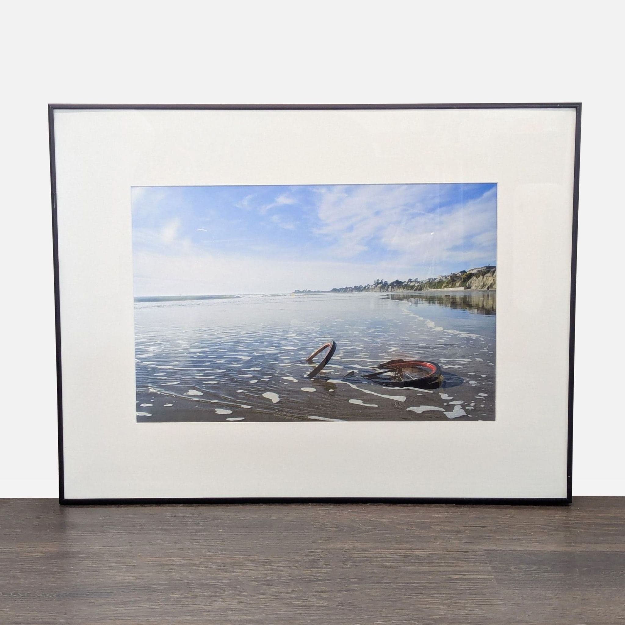 Framed Print – Abandoned Bicycle Wheel on Beach with Scenic View