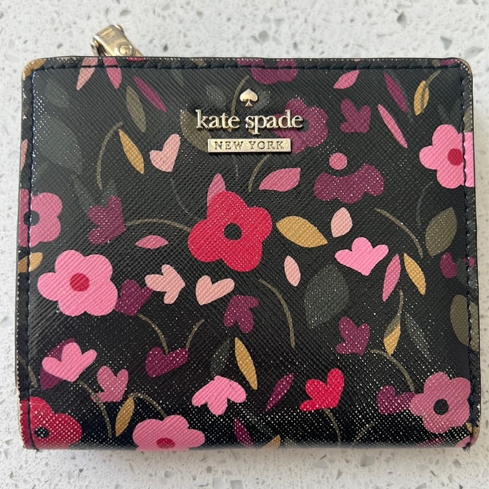 This is a previously used Kate Spade floral wallet. Overall in good condition.