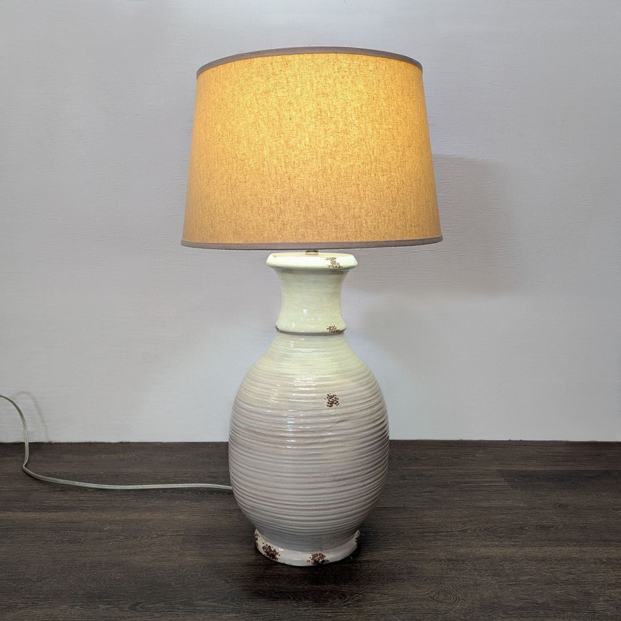 Ceramic Table Lamp with Beige Shade, Ribbed Texture, and Rustic Accents